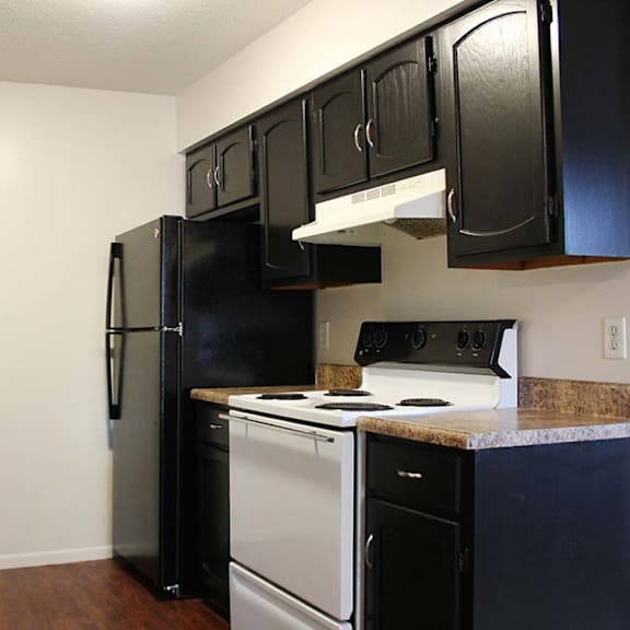 a kitchen with a white stove top oven next to a refrigerator at hunter ridge apartments, cincinnati, oh