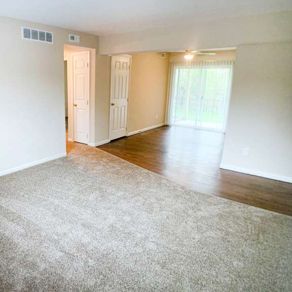 a room with a carpeted floor and a door leading to another room.