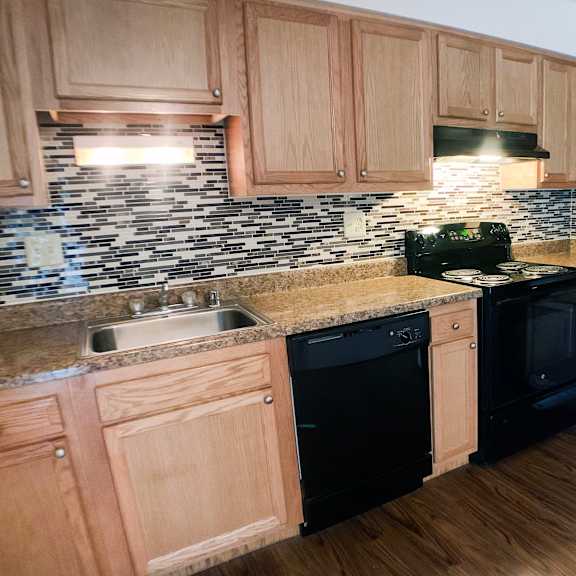 a kitchen with wooden cabinets and black appliances.