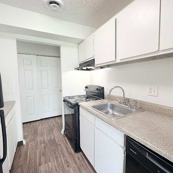 a kitchen with black appliances and white cabinets.