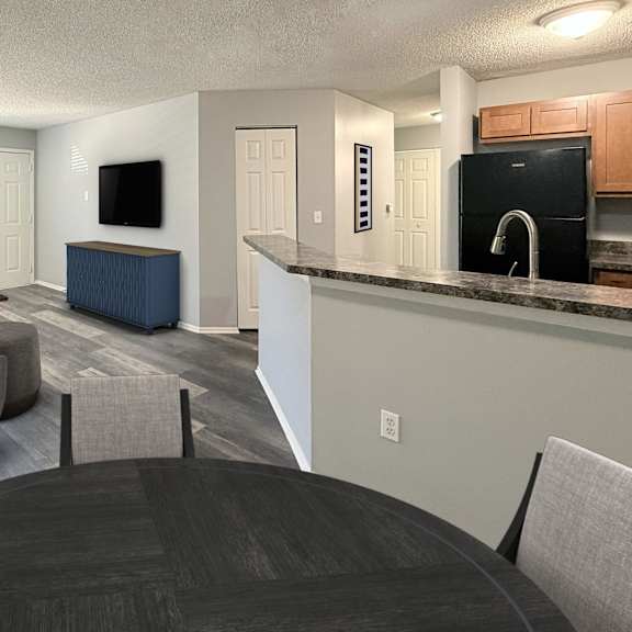 a modern living room with a dark wood table and grey couch.