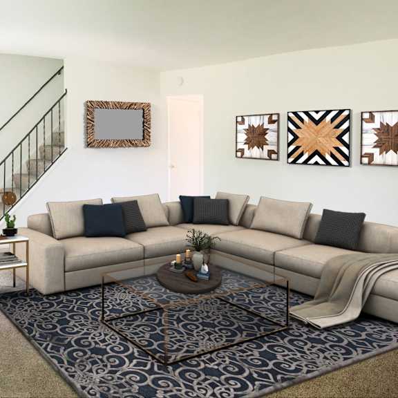 a living room with a beige couch, a coffee table, and a staircase.