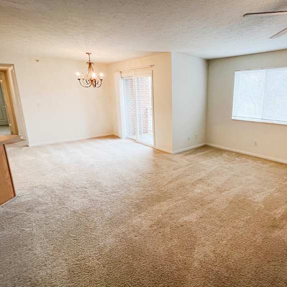 an empty living room with carpet and a ceiling fan  at walton ridge apartments, walton, ky