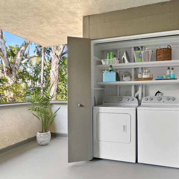 A laundry room with a washer and dryer built into a cabinet.