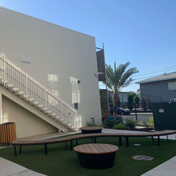 a modern building with a staircase and a bench in front.