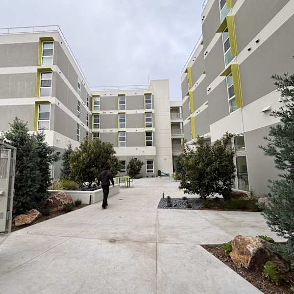 a person is walking in a courtyard between two buildings.