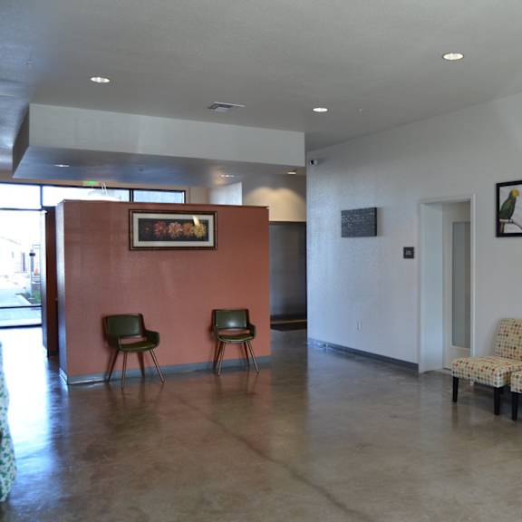 a hallway with a bench and a painting on the wall.