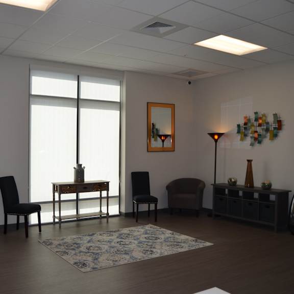 a living room with a table and chairs in front of a window.