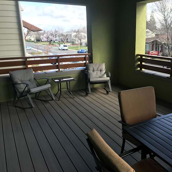 a balcony with a table and chairs overlooking a street.