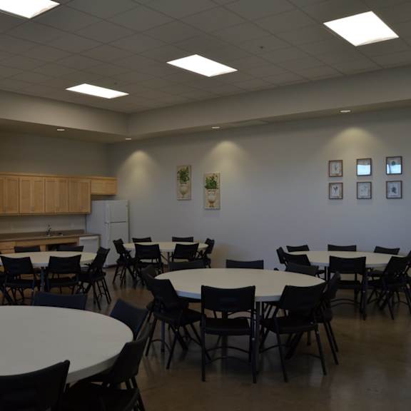 a room with tables and chairs is empty.
