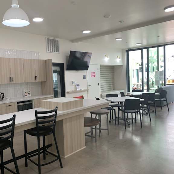 a kitchen with a white counter and black chairs.