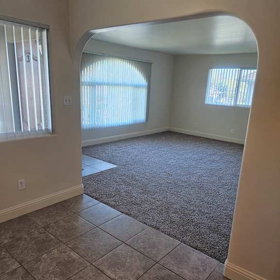 a room with a large arched doorway and a carpeted floor.