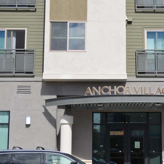 the front of a building with the name anchor village on it.
