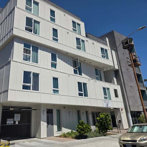 a modern building with a white and grey facade and multiple windows.