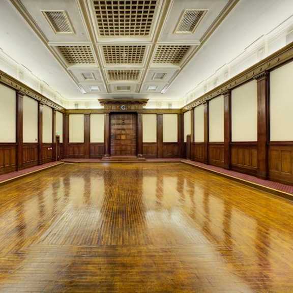 a long hallway with wooden floors and doors on both sides.