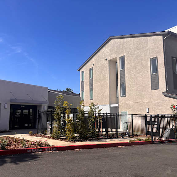 a modern building with a black gate and a red curb.