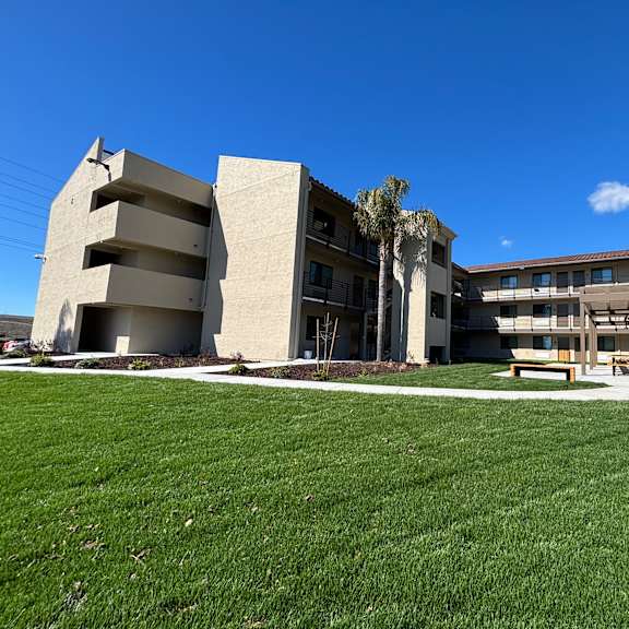 a modern building with a green lawn in front.