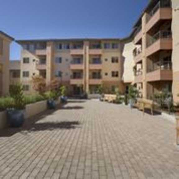 a courtyard with paved ground and apartment buildings in the background.