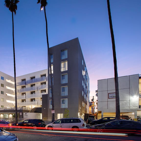 a modern building with palm trees in front of it.