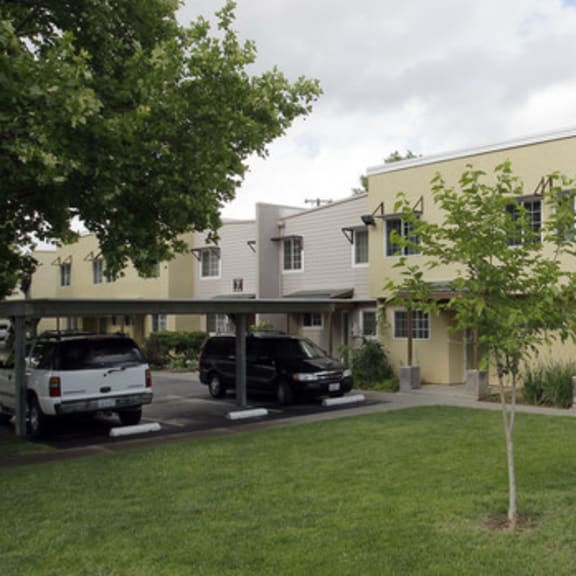 a yellow building with a black fence in front.