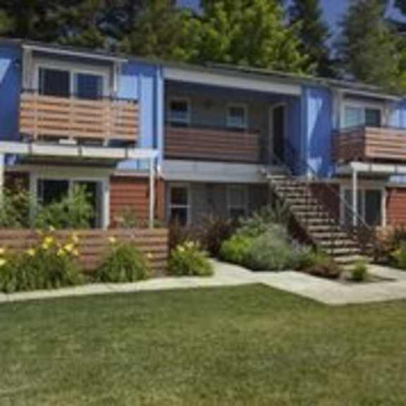 a small house with a blue and brown exterior.