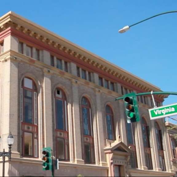 a street view of a building with a traffic light on green.