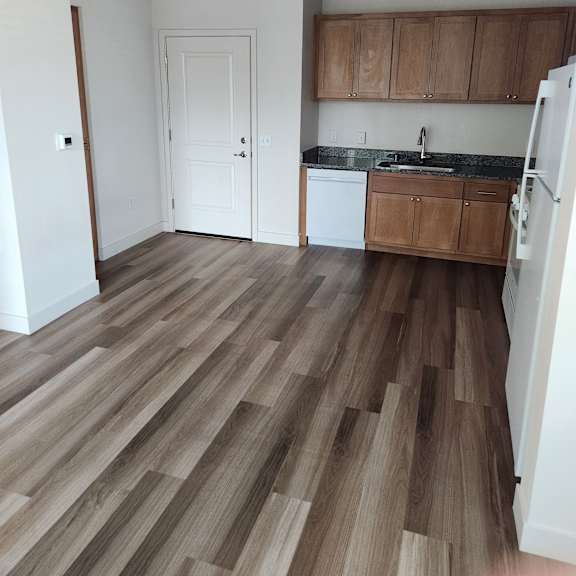 a kitchen with wooden floors and white walls.