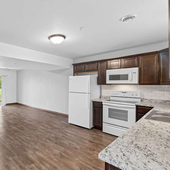 a kitchen with white appliances and brown cabinets.