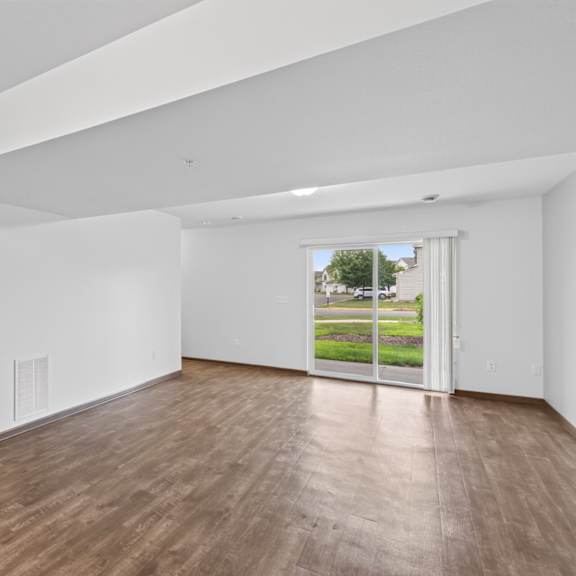 a room with a wooden floor and a door leading to a balcony.