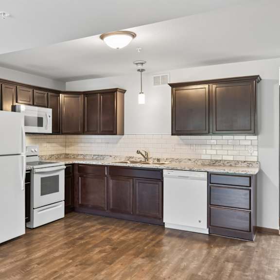 a kitchen with white appliances and brown cabinets.