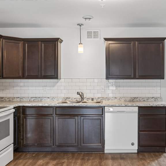 a kitchen with dark brown cabinets and a white fridge.