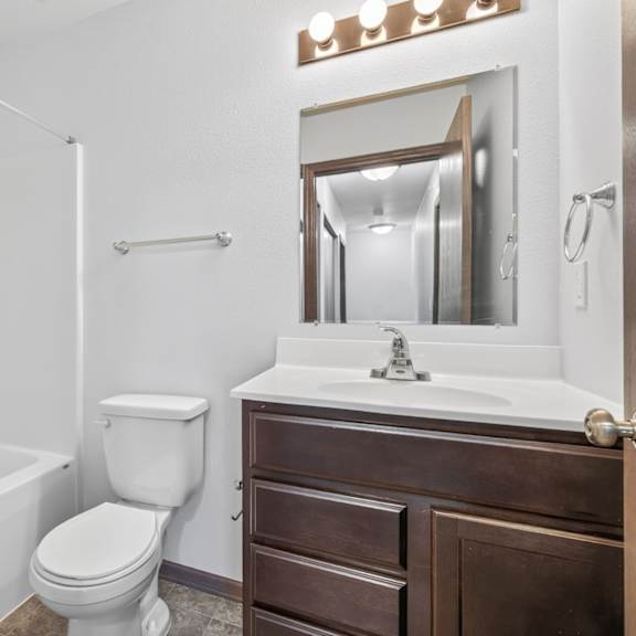 a white bathroom with a toilet, sink, and bathtub.
