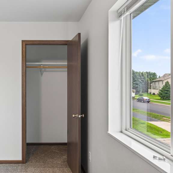 a room with a brown door and a window showing a street view.