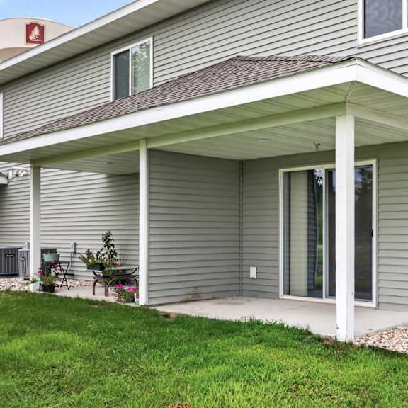 a house with a grey siding and a covered patio area.