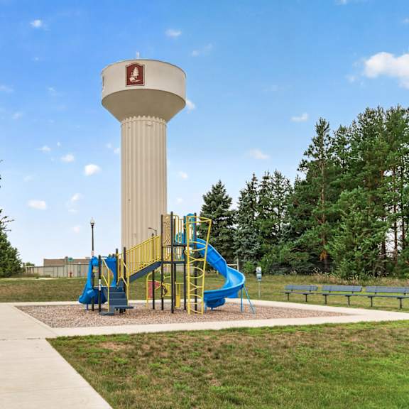 a playground with a water tower in the background.