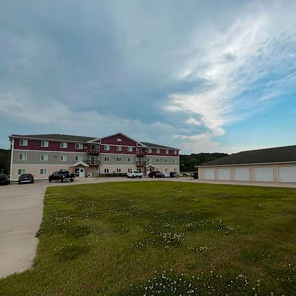 a large building with a red roof is surrounded by a grassy field.