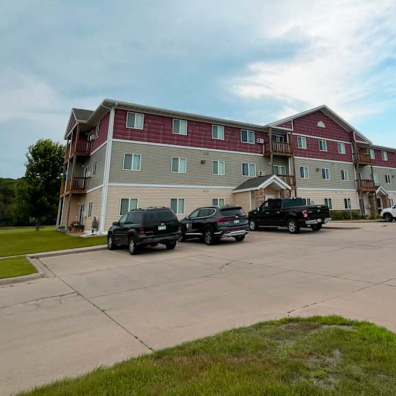 two black trucks parked in front of a red and white building.