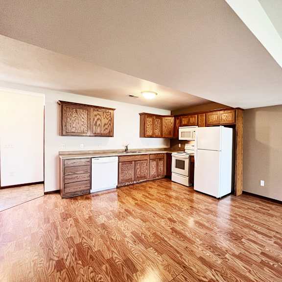 a kitchen with wooden floors and white appliances.