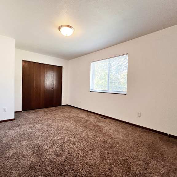 a room with a brown carpet and a brown door.