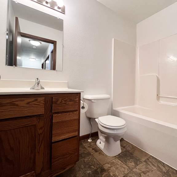 a white toilet sits next to a white bathtub in a bathroom.