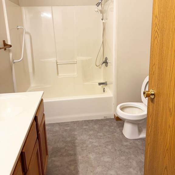 a white bathroom with a toilet, tub, and sink.