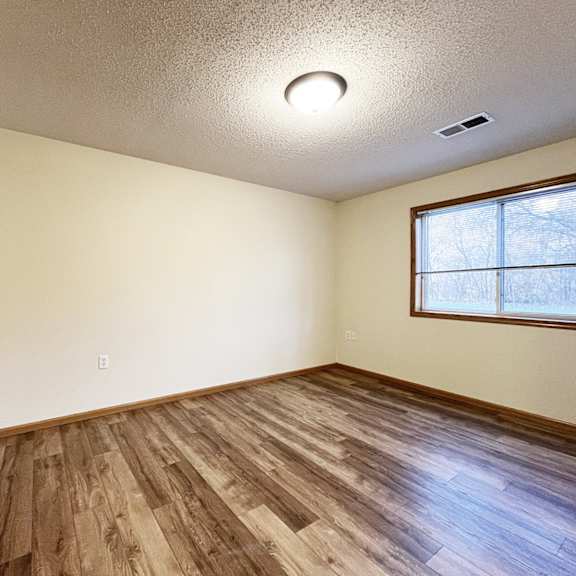 a room with wooden flooring and a window.