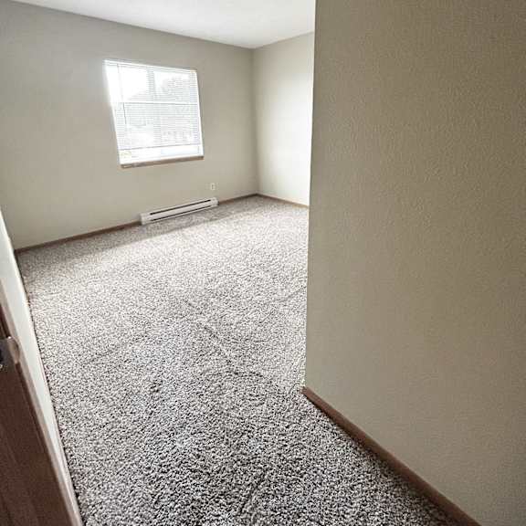 a room with a carpeted floor and a window.