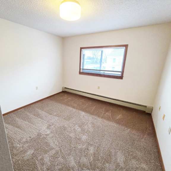 a room with a carpeted floor and a window.