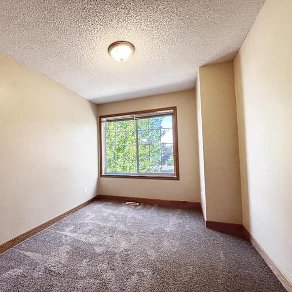a room with a window and carpeted floor.