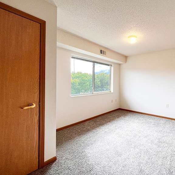 a room with a carpeted floor and a window.