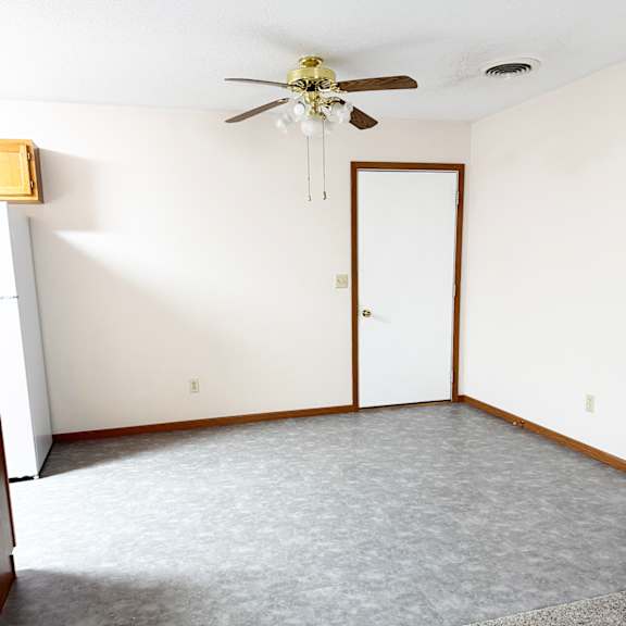 a room with a ceiling fan and a door.