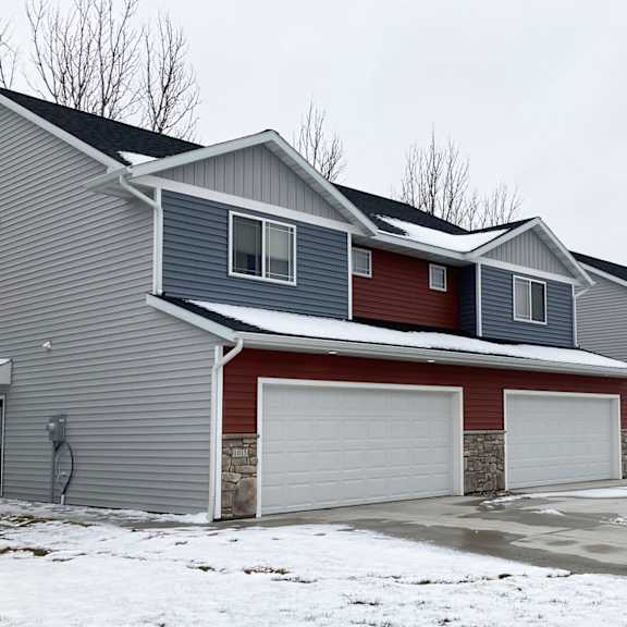 a row of houses with garages in front.