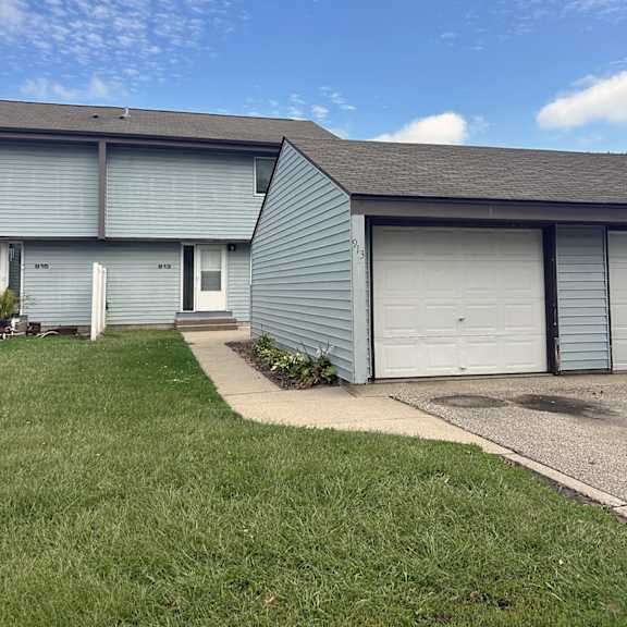 a blue house with a white door and a garage door.