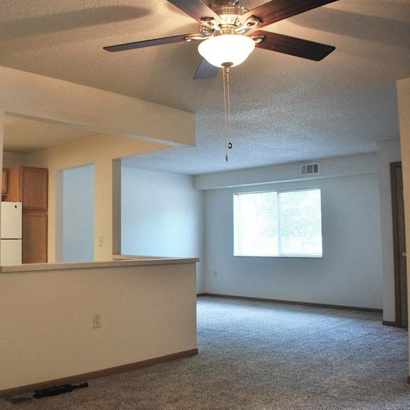 a room with a ceiling fan and a window.